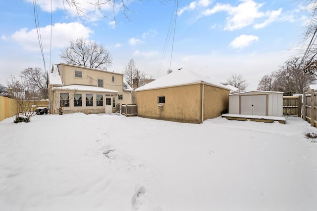 snow covered property with a storage unit