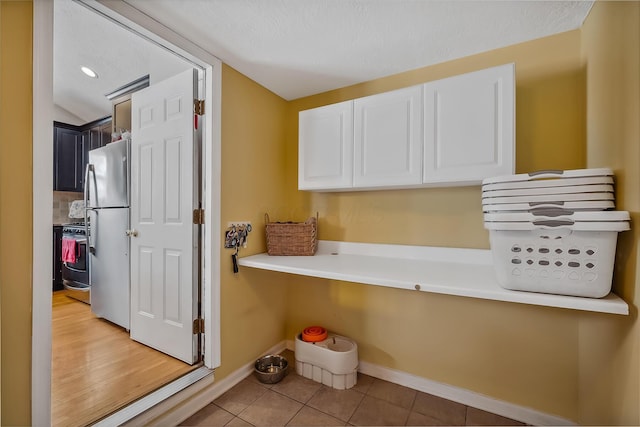 clothes washing area with light tile patterned floors