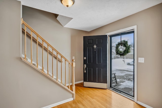 foyer entrance featuring a textured ceiling and light hardwood / wood-style flooring