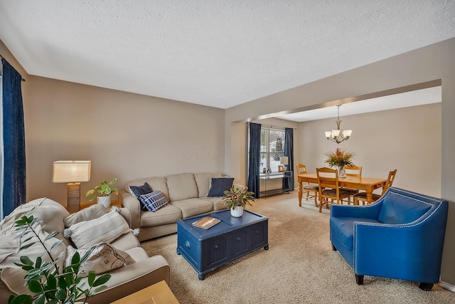 carpeted living room featuring a chandelier and a textured ceiling