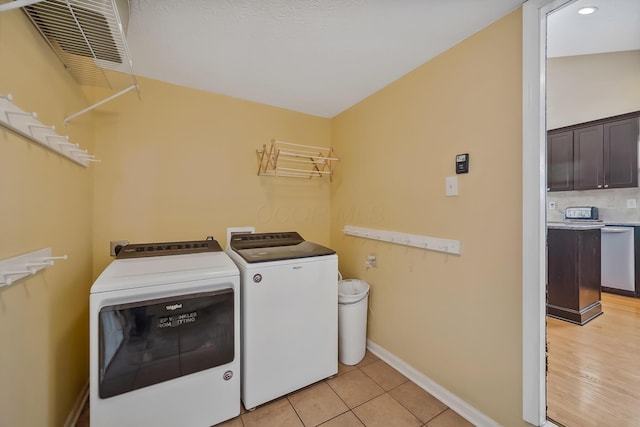 washroom featuring washing machine and clothes dryer and light tile patterned flooring