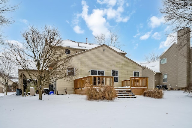 snow covered rear of property featuring a deck