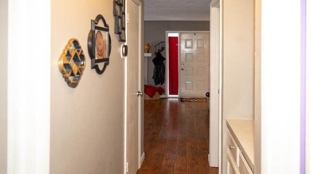 hallway with dark hardwood / wood-style flooring and a textured ceiling