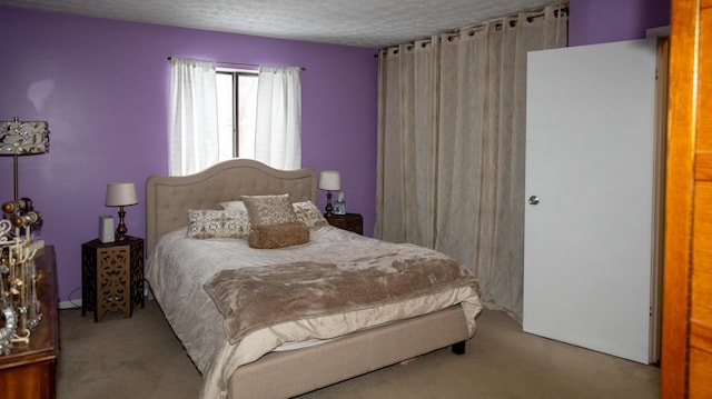 bedroom with light colored carpet and a textured ceiling