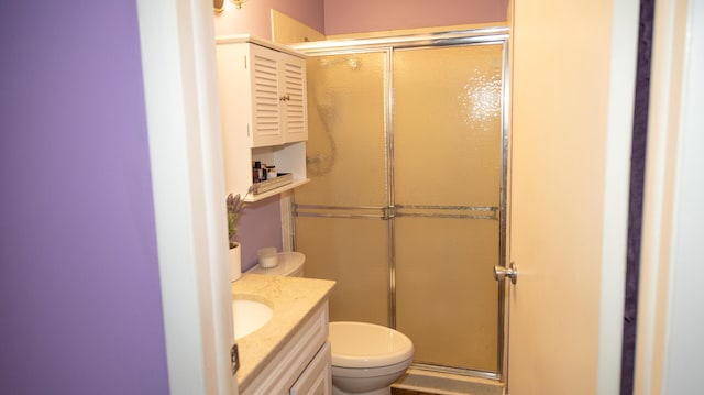 bathroom with vanity, toilet, and a shower with shower door