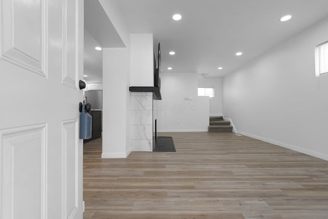 unfurnished living room with a fireplace and light wood-type flooring