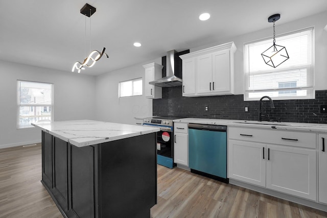 kitchen featuring appliances with stainless steel finishes, wall chimney exhaust hood, a kitchen island, sink, and white cabinetry