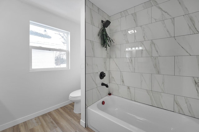 bathroom featuring tiled shower / bath combo, toilet, and wood-type flooring