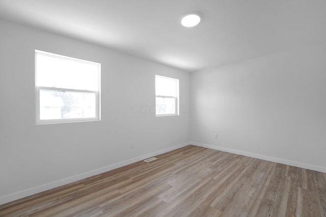 unfurnished room with light wood-type flooring