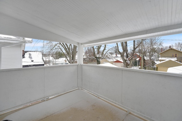 snow covered patio featuring a balcony