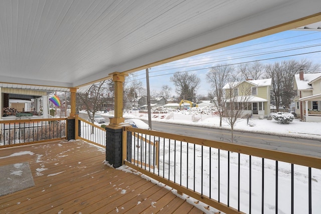 snow covered deck with a porch