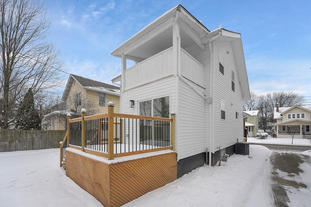 snow covered house featuring cooling unit