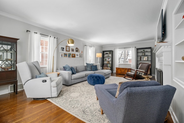 living room featuring a wealth of natural light, a fireplace, dark hardwood / wood-style floors, and ornamental molding