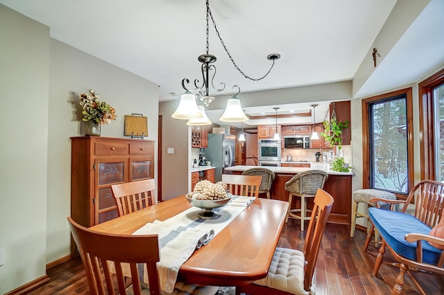 dining room with dark hardwood / wood-style floors and an inviting chandelier