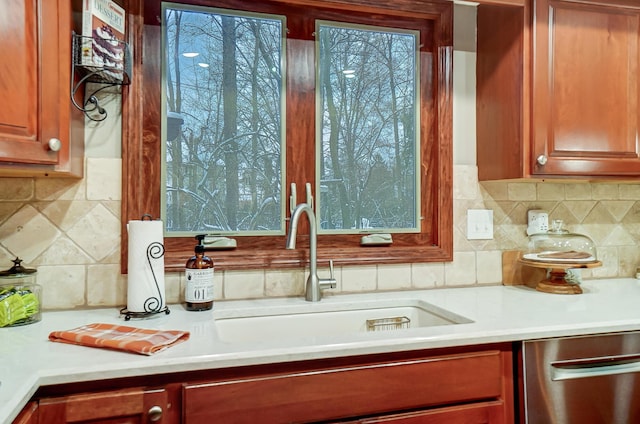 kitchen featuring stainless steel dishwasher, decorative backsplash, and sink