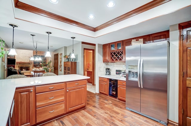 kitchen featuring stainless steel fridge, backsplash, a brick fireplace, ornamental molding, and beverage cooler