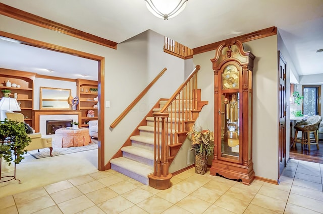 staircase with carpet, built in shelves, and ornamental molding