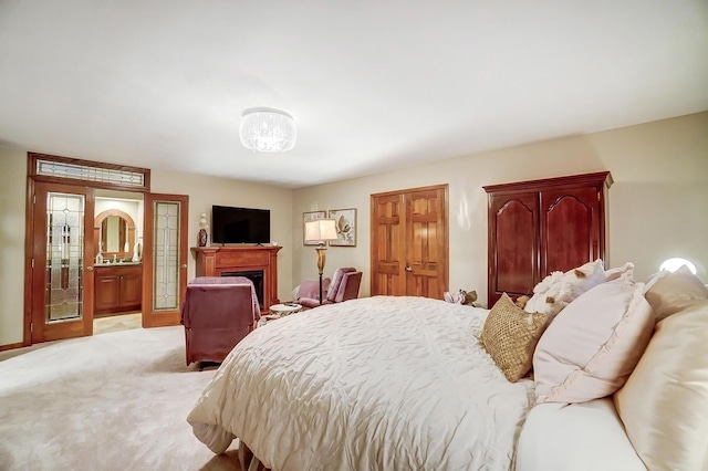 bedroom with ensuite bath and light colored carpet