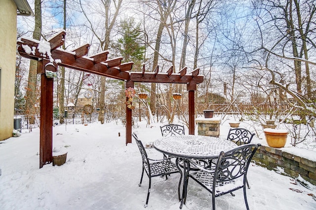 snow covered patio with a pergola