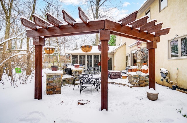 snow covered patio featuring a pergola and a sunroom