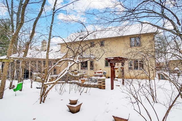 view of snow covered back of property