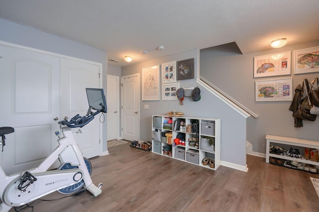 exercise area featuring hardwood / wood-style floors and a textured ceiling