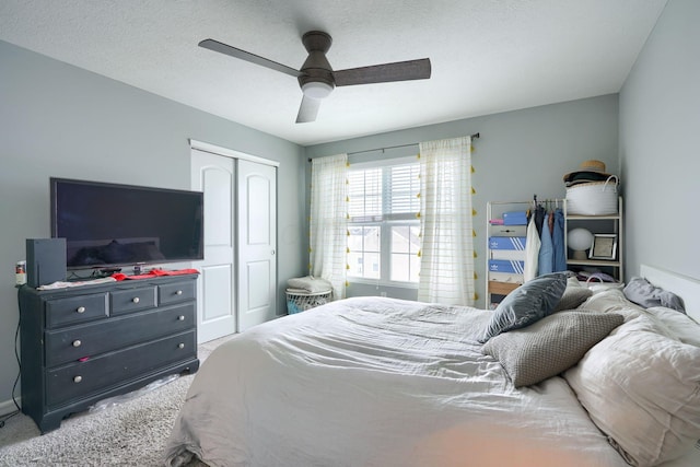 carpeted bedroom featuring a textured ceiling, a closet, and ceiling fan