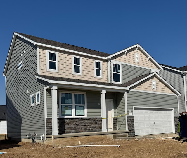 craftsman house with a garage, stone siding, and roof with shingles