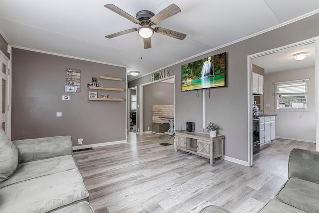 living room featuring light wood-type flooring, ceiling fan, and ornamental molding