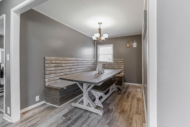 dining room featuring hardwood / wood-style flooring, ornamental molding, and a notable chandelier