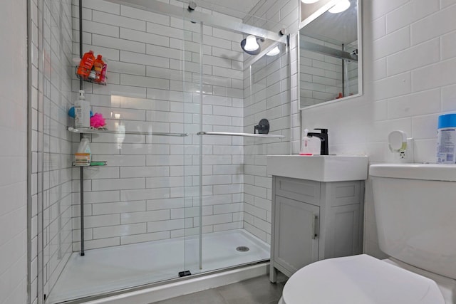 bathroom featuring vanity, a shower with shower door, and toilet