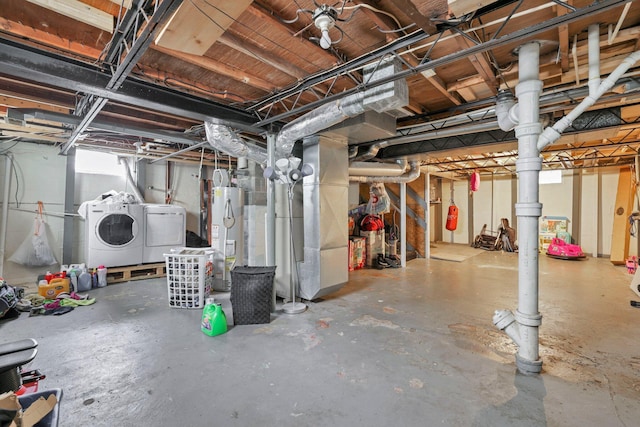 basement featuring washing machine and clothes dryer, heating unit, and gas water heater