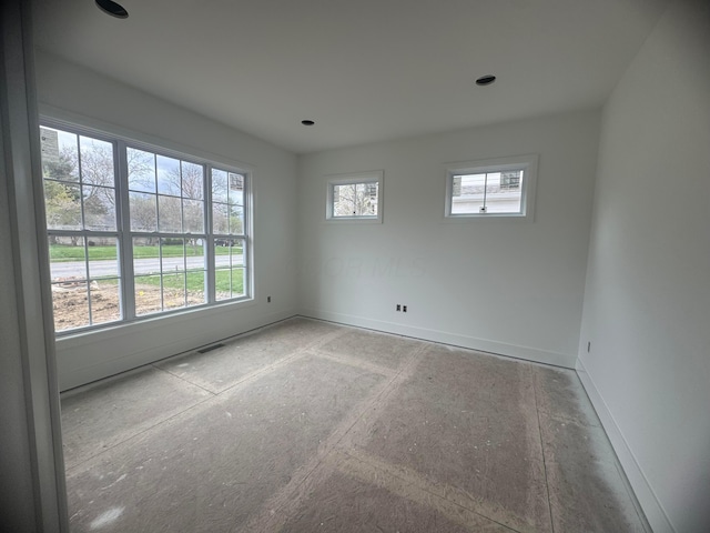spare room featuring visible vents and baseboards