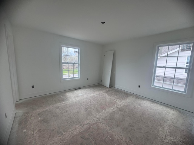 unfurnished room with visible vents and baseboards