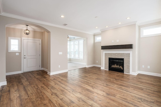 unfurnished living room featuring wood-type flooring, ceiling fan, and ornamental molding