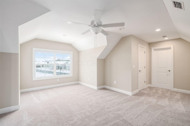 additional living space with light carpet, vaulted ceiling, visible vents, and baseboards