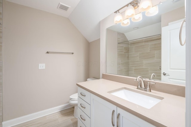 bathroom featuring baseboards, visible vents, toilet, vaulted ceiling, and vanity