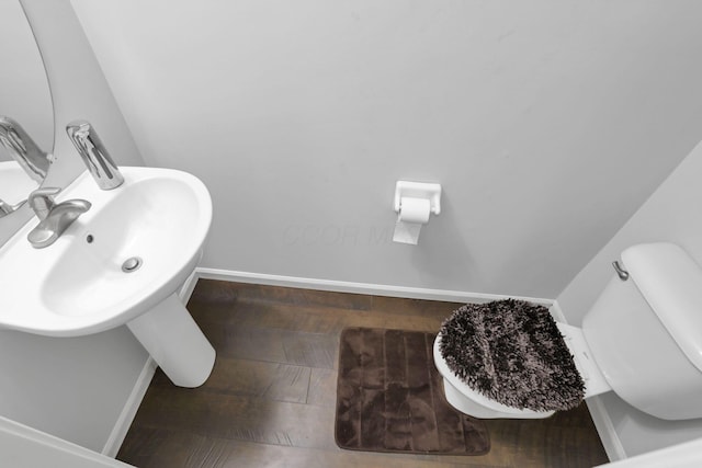 bathroom with hardwood / wood-style flooring and toilet