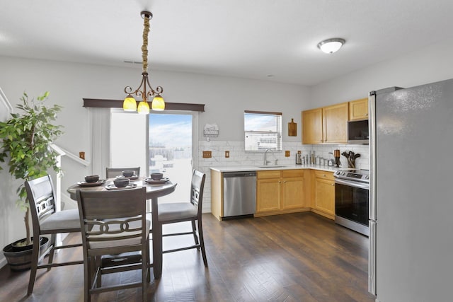 kitchen with light brown cabinets, sink, decorative light fixtures, appliances with stainless steel finishes, and a notable chandelier