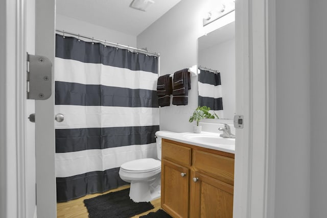 bathroom featuring vanity, hardwood / wood-style flooring, toilet, and walk in shower