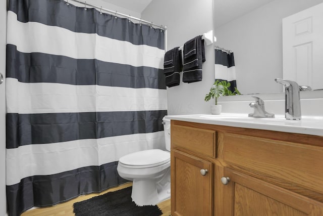 bathroom with hardwood / wood-style floors, vanity, and toilet