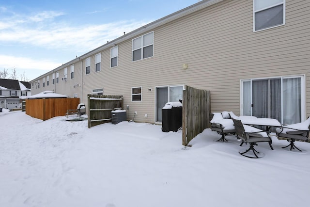 snow covered back of property with central AC unit