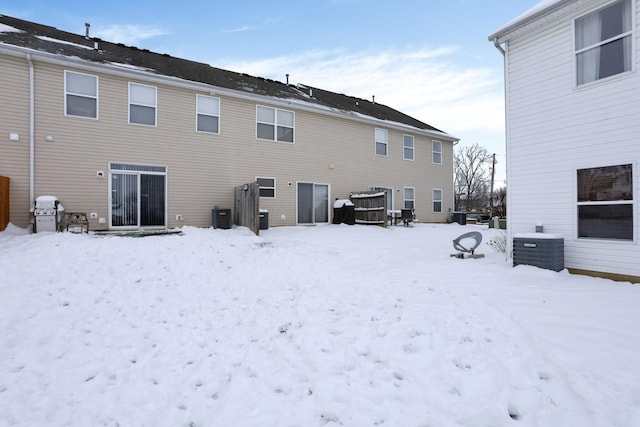 snow covered rear of property with central air condition unit