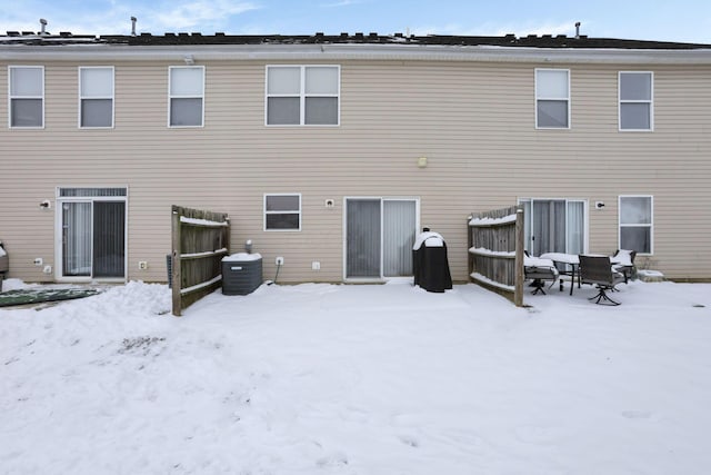 snow covered back of property with central AC unit