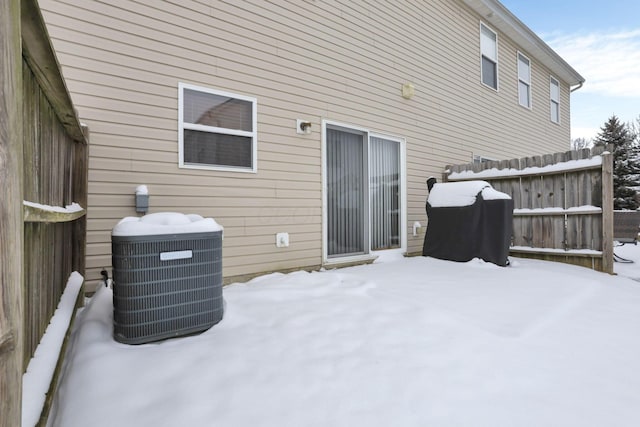 snow covered rear of property with central AC