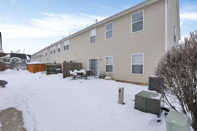 view of snow covered back of property