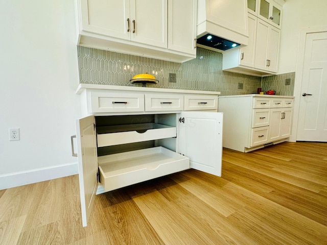 kitchen featuring backsplash, light hardwood / wood-style flooring, and white cabinets