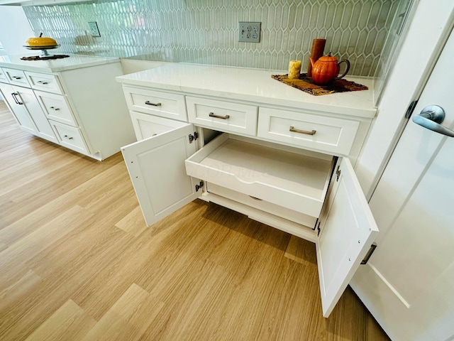 interior space with tasteful backsplash and white cabinetry