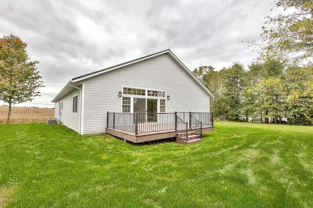 rear view of house with central air condition unit, a deck, and a lawn