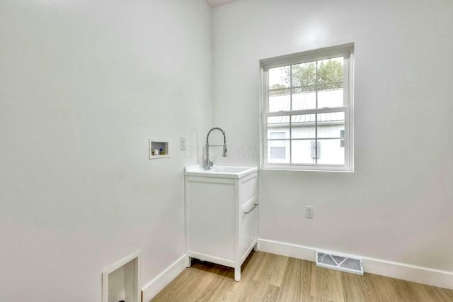 laundry room with hookup for a washing machine, sink, plenty of natural light, and light wood-type flooring